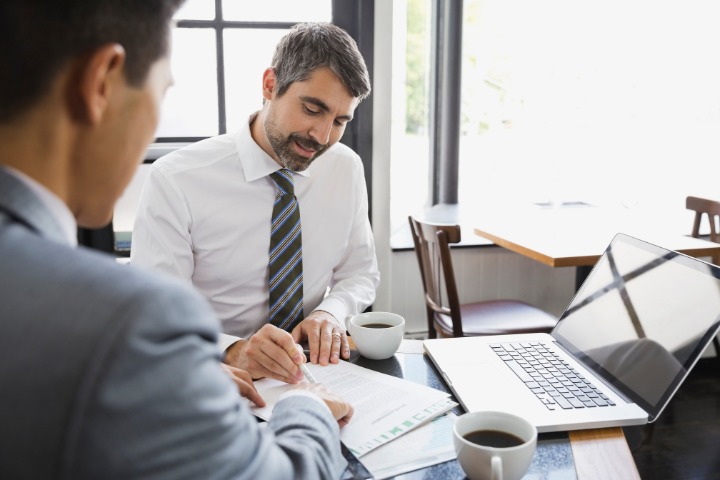 Two businessmen discussing documents during a meeting