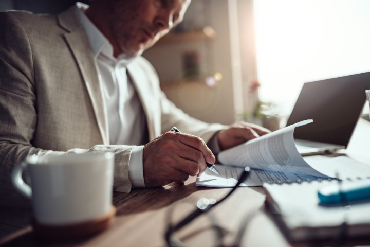 Engineer focused on signing documents at his desk