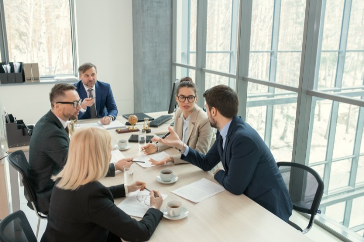 Legal professionals having a serious discussion during a team meeting, reviewing documents and sharing ideas