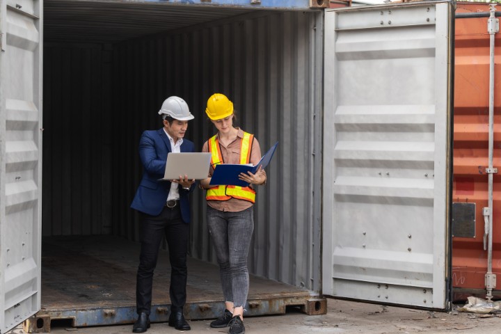 Bond specialist and construction engineer reviewing project documentation on-site