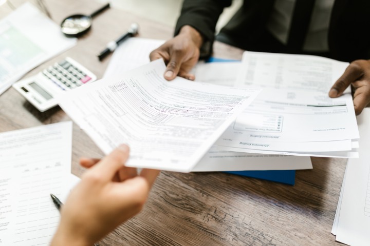 Detailed contract bond documents being passed across a desk