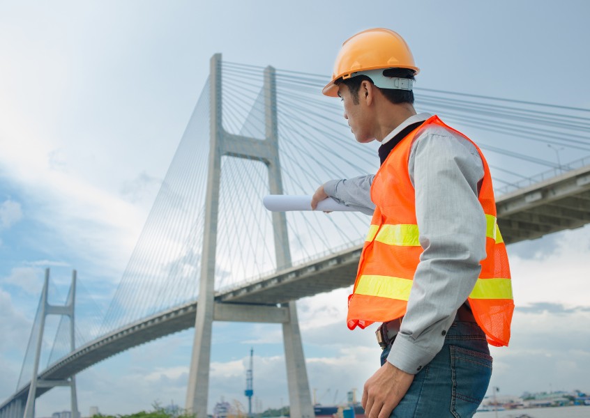 Contractor inspecting a bridge construction project secured by contract bonds