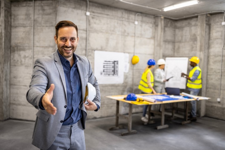 Smiling contractor inviting a surety team to evaluate the company before issuing bid bonds