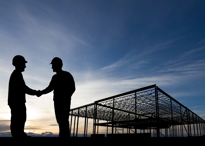 A handshake between a contractor and consultant following a successful bond agreement